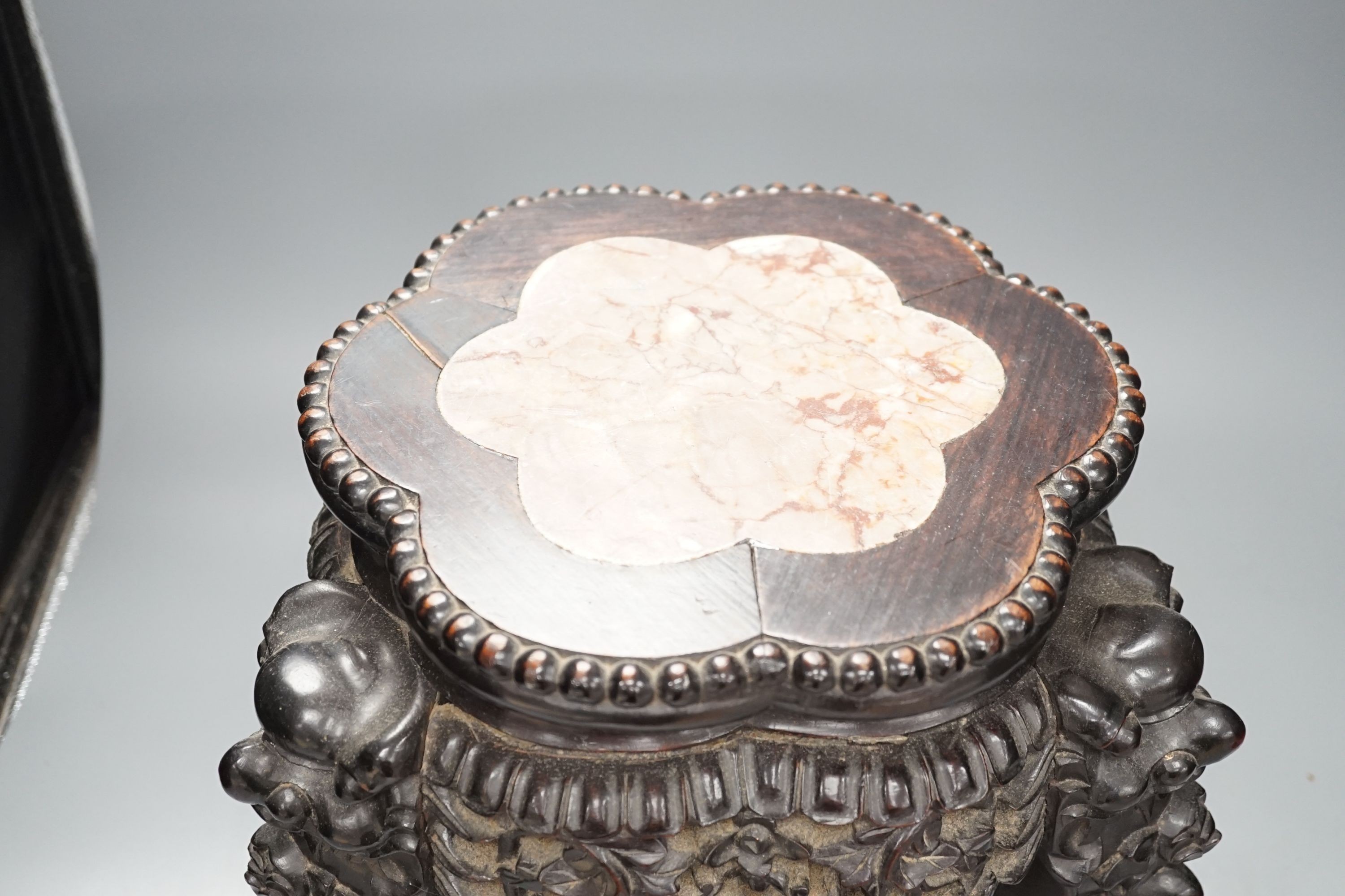 AChinese carved wood jardiniere stand, late Qing dynasty, with hard stone inset, top 26 cms diameter.